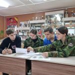 Четверо человек сидят за столами и отвечают на вопросы написанные на бумаге